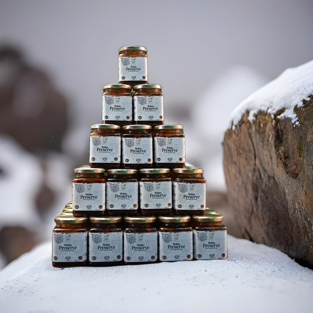 Stack of Mahua Preserve (Mahua Aachar) jars by Jai Jungle, a tribal-crafted pickle made from Mahua flowers and traditional forest spices, displayed in a pyramid formation against a natural backdrop.