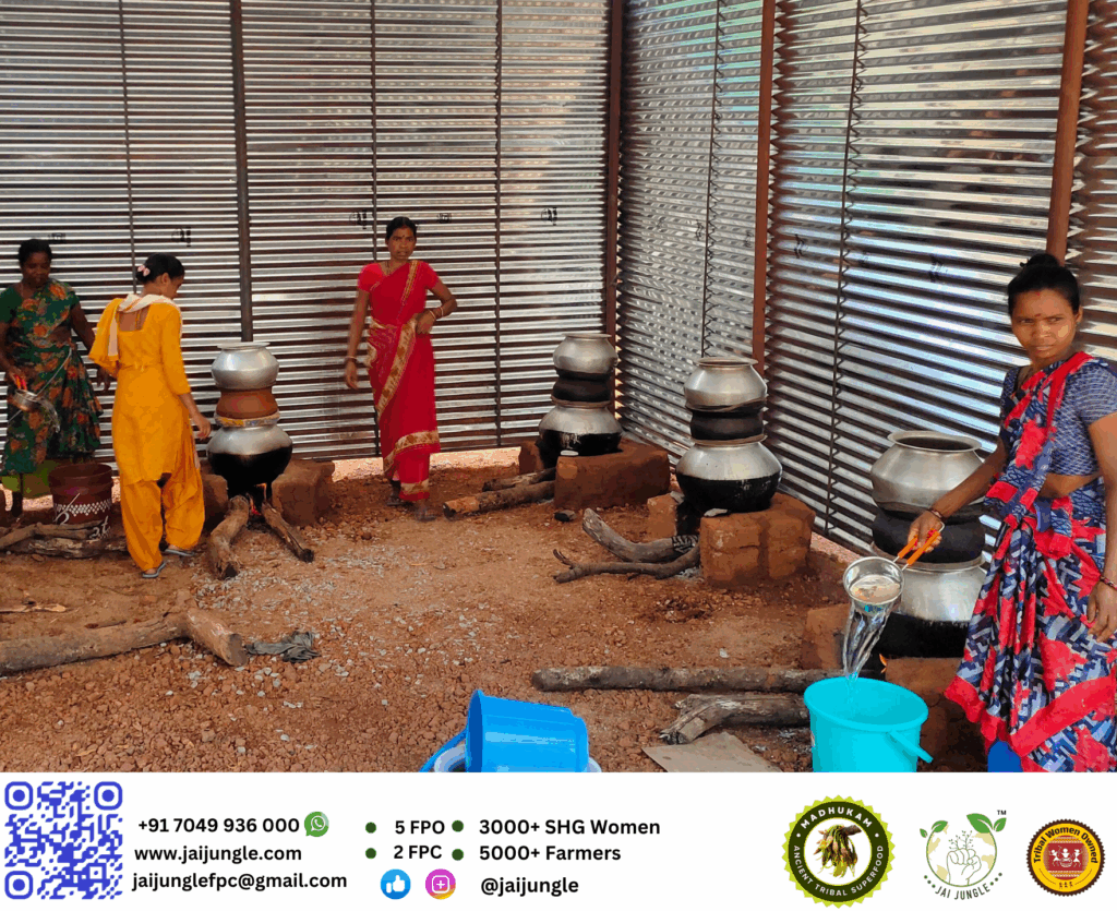Adivasi women distilling Mahua flowers in a traditional setup, using large earthen and metal pots, to produce Mahua-based sanitiser in Chhattisgarh.